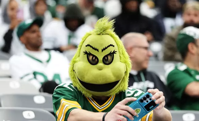 A Green Bay Packers fan wears a Grinch costume before an NFL football game against the New York Jets in East Rutherford, N.J., Sunday, Sept. 20, 2026. (AP Photo/Adam Hunger)