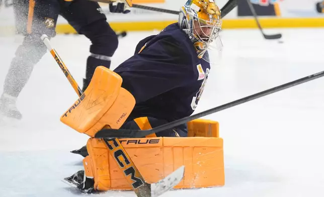Nashville Predators goaltender Juuse Saros (74) deflects a shot on goal during NHL hockey training camp Thursday, Sept. 17, 2026, in Nashville, Tenn. (AP Photo/George Walker IV)