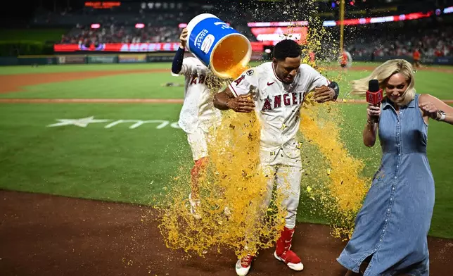 Los Angeles Angels' Christian Moore, center, is showered with an ice bucket after hitting a walk-off single during the 11th inning of a baseball game against the Minnesota Twins, Saturday, Sept. 19, 2026, in Anaheim, Calif. (AP Photo/William Liang)