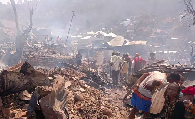 People walk through smoke after a fire at a school killed several people in Bukavu, Congo, Thursday, Sept. 10, 2026. (AP Photo/Janvier Barhahiga)