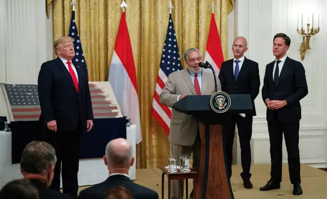 FILE - Lonnie Bunch, the New Secretary of the Smithsonian, joined by President Donald Trump, left, Dutch collector Bert Kreuk, second from right, and Dutch Prime Minister Mark Rutte, right, speaks during a ceremony in the East Room of the White House, July 18, 2019, in Washington. (AP Photo/Carolyn Kaster, File)