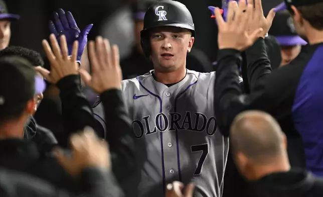 Colorado Rockies' TJ Rumfield celebrates with teammates in the dugout after hitting a solo home run during the second inning of a baseball game against the Chicago White Sox, Friday, Sept. 25, 2026, in Chicago. (AP Photo/Paul Beaty)