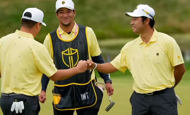 International teams' Hideki Matsuyama, of Japan, right, celebrates with Sungjae Im, of South Korea, on the eighth green against the USA team during the Presidents Cup golf tournament second round foursomes match at Medinah Country Club, Friday, Sept. 25, 2026, in Medinah, Ill. (AP Photo/Chris Carlson)