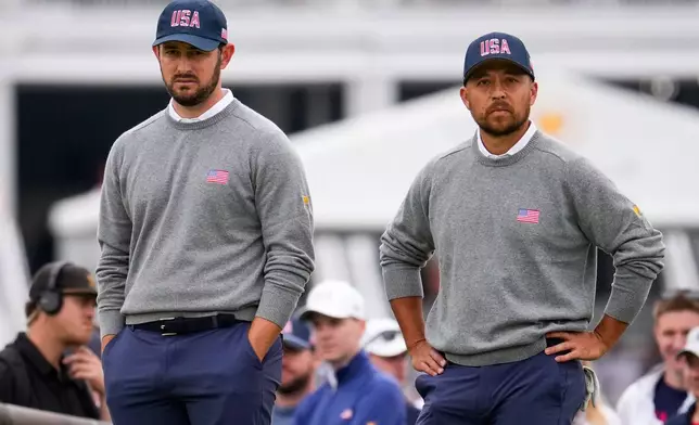 USA teams' Patrick Cantlay, left, and Xander Schauffele watch the International team play on the seventh green during the Presidents Cup golf tournament second round foursomes match at Medinah Country Club, Friday, Sept. 25, 2026, in Medinah, Ill. (AP Photo/Matt Slocum)