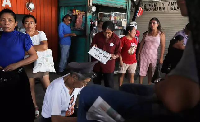 A person reads a newspaper at a market in Campeche, Mexico, Thursday, Sept. 17, 2026. (AP Photo/Martin Zetina)