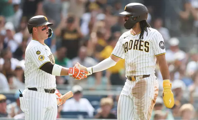 San Diego Padres' Fernando Tatis Jr., right, celebrates with teammate Jackson Merrill, left, after scoring on Manny Machado's RBI single in the third inning of a baseball game against the Washington Nationals, Monday, Sept. 7, 2026, in San Diego. (AP Photo/Karl Anderson)