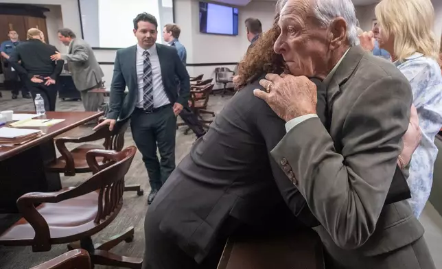 Tim Miller, father of Laura Miller, embraces Galveston County Chief Assistant District Attorney Kate Willis, as James Dolphs Elmore Jr., far left, walks in handcuffs from the courtroom after he was found guilty of manslaughter in Galveston, Texas, Wednesday, Sept. 2, 2026. (Stuart Villanueva/The Galveston County Daily News via AP, Pool)