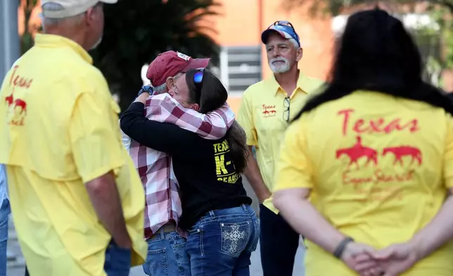 FILE - A member of Texas EquuSearch hugs Tim Miller, the group's founder whose daughter, Laura, was killed and her body found in a League City field in 1986, outside the Galveston County Courthouse in downtown Galveston, Texas, April 1, 2026. (Jennifer Reynolds /The Galveston County Daily News via AP, File)