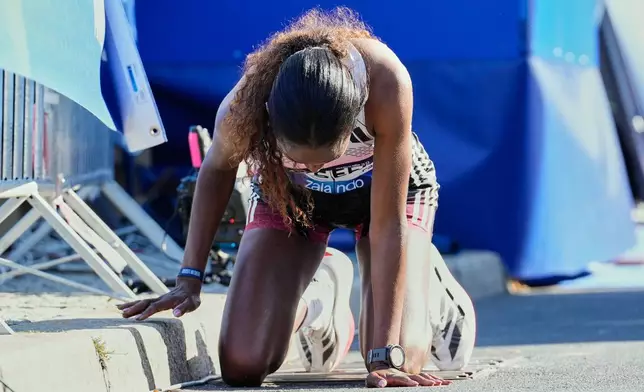Ethiopia's Tigist Assefa kneels on the ground after winning he Berlin Marathon in Berlin, Germany, Sunday, Sept. 27, 2026. (AP Photo/Ebrahim Noroozi)