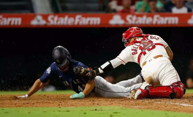 Los Angeles Angels catcher Moises Ballesteros (13), right, tags out Seattle Mariners' Julio Rodriguez (44), left, at home plate during the fifth inning of a baseball game Wednesday, Sept. 16, 2026, in Anaheim, Calif. (AP Photo/Caroline Brehman)