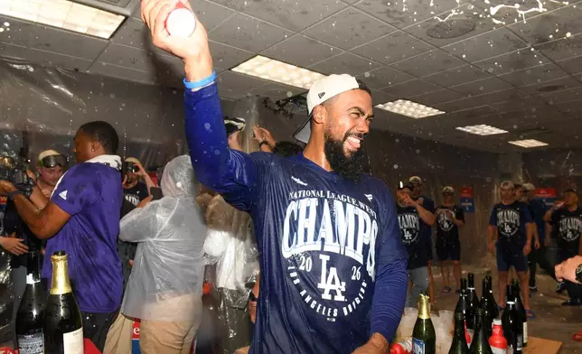 Los Angeles Dodgers left fielder Teoscar Hernández (37) celebrates in the locker room after the Dodgers clinch the playoffs during a baseball game against the Cincinnati Reds on Thursday, Sept. 17, 2026, in Cincinnati. (AP Photo/Tanner Pearson)