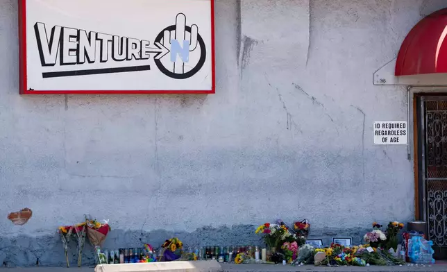 A growing memorial sits outside the Venture-N Bar in Tucson, Ariz., Tuesday, Sept. 1, 2026, for Vincent Siquieros and Cameron Capara, who were fatally shot in the parking lot of the gay bar shortly after midnight Monday. (AP Photo/Rebecca Noble)