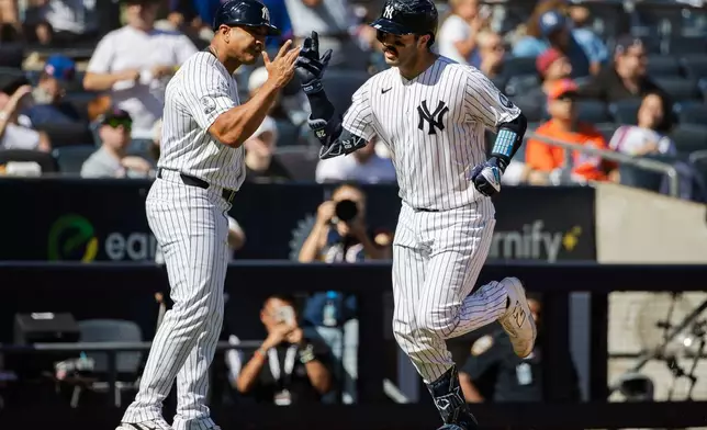 New York Yankees' Austin Wells, right, runs the bases after hitting a home run during the third inning of a baseball game against the New York Mets, Sunday, Sept. 13, 2026, in New York. (AP Photo/Angelina Katsanis)
