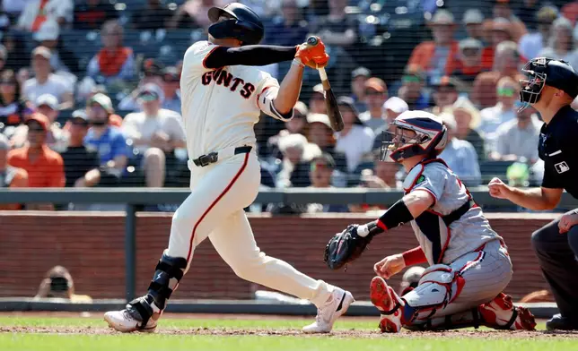 San Francisco Giants' Shay Whitcomb hits a two-run single in front of Minnesota Twins catcher Ryan Jeffers, right, during the fourth inning of a baseball game in San Francisco, Wednesday, Sept. 23, 2026. (AP Photo/Jed Jacobsohn)