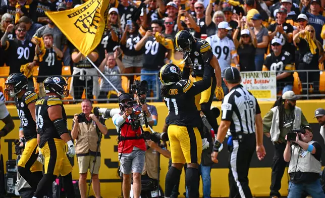 Pittsburgh Steelers wide receiver Roman Wilson (14) is lifted by offensive tackle Max Iheanachor (71) after Wilson scored a touchdown during the first half of an NFL football game against the Cincinnati Bengals in Pittsburgh, Sunday, Sept. 27, 2026. (AP Photo/Justin Berl)