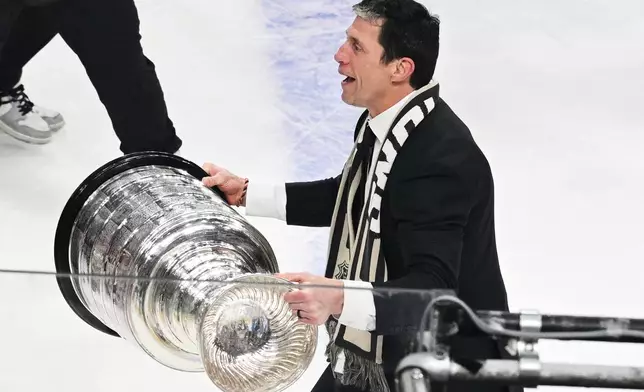 FILE - Carolina Hurricanes head coach Rod Brind'Amour, right, lifts the Stanley Cup after a win over the Vegas Golden Knights in Game 6 of the NHL hockey Stanley Cup Final series, June 14, 2026, in Las Vegas. (AP Photo/Candice Ward, File)