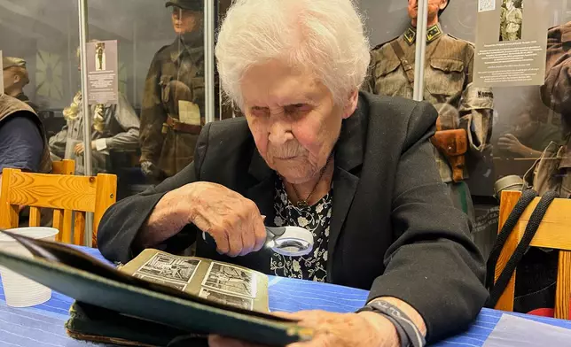 Pirkko Naukkarinen, a Finnish war veteran, looks over photos from World War II in an album at a museum in Kuopio, Finland, Tuesday, Sept. 1, 2026. (AP Photo/Emma Burrows)