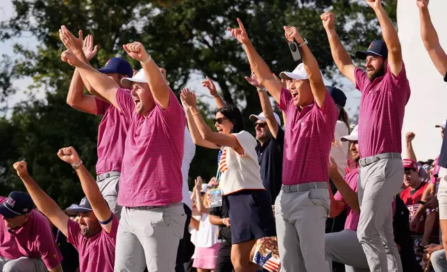 Members of the USA team celebrateJackson Koivun's win on the 18th green against the International team during a Presidents Cup golf tournament final round singles match at Medinah Country Club, Sunday, Sept. 27, 2026, in Medinah, Ill. (AP Photo/Matt Slocum)