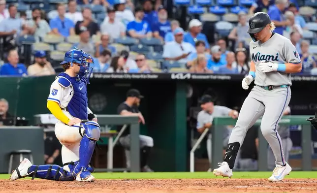 Miami Marlins' Kyle Stowers, right, crosses the plate to score after hitting a solo home run during the fifth inning of a baseball game against the Kansas City Royals, Tuesday, Sept. 1, 2026, in Kansas City, Mo. (AP Photo/Charlie Riedel)