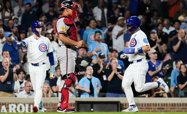 Chicago Cubs' Matt Shaw, right, scores on a sacrifice fly by Miguel Amaya as Atlanta Braves catcher Drake Baldwin looks to the field during the fourth inning of a baseball game in Chicago, Tuesday, Sept. 15, 2026. (AP Photo/Nam Y. Huh)