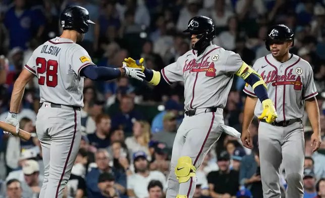 Atlanta Braves' Ronald Acuña Jr., center, celebrates with Matt Olson, left, and Drake Baldwin after hitting a two-run home run during the sixth inning of a baseball game against the Chicago Cubs in Chicago, Tuesday, Sept. 15, 2026. (AP Photo/Nam Y. Huh)