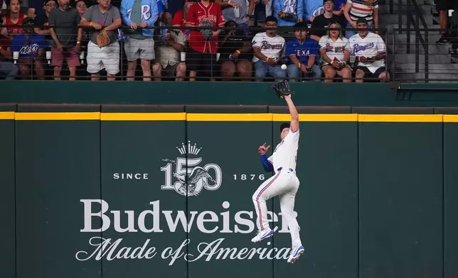 Texas Rangers left fielder Wyatt Langford jumps to catch a fly out against New York Mets' Francisco Alvarez during the second inning of a baseball game, Wednesday, Sept. 23, 2026, in Arlington, Texas. (AP Photo/LM Otero)