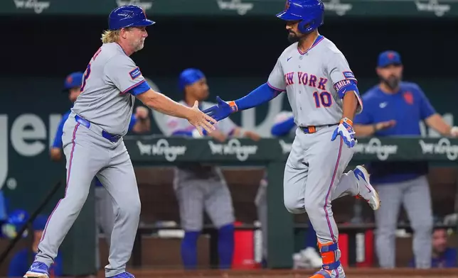 New York Mets' Marcus Semien (10) is congratulated by third base coach Jacob Latz as Semien runs the bases on a solo home run during the eighth inning of a baseball game against the Texas Rangers, Wednesday, Sept. 23, 2026, in Arlington, Texas. (AP Photo/LM Otero)