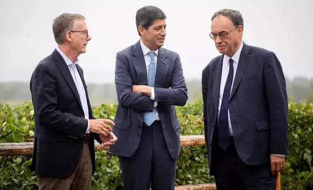 Fed Chair Kevin Warsh, center, talks to Bank of England Governor Andrew Bailey, right, and Bank of Canada Governor Tiff Macklem at the annual Jackson Hole Economic Policy Symposium on Friday, Aug. 28, 2026, in Moran, Wyo. (AP Photo/Amber Baesler)