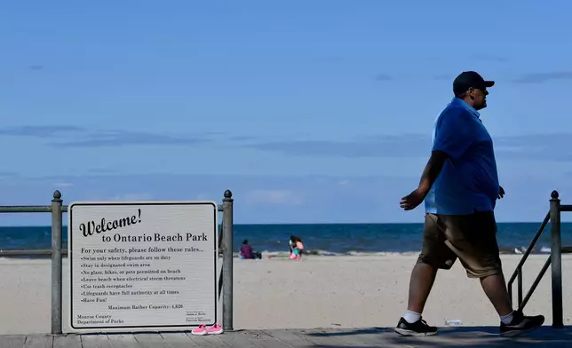 Signs mark the entrance to Ontario Beach Park on the shore of Lake Ontario, Tuesday, Aug. 25, 2026, in Rochester, N.Y. (AP Photo/Adrian Kraus)