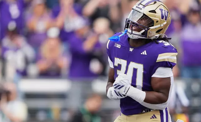 Washington running back Ansu Sanoe reacts after scoring a touchdown against Utah State during the first half of an NCAA college football game Saturday, Sept. 12, 2026, in Seattle. (AP Photo/Lindsey Wasson)