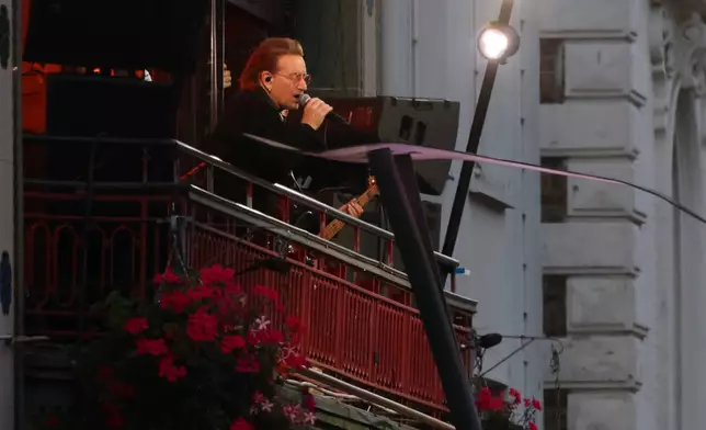 U2 perform an impromptu concert from a balcony in central Dublin, Ireland , Friday, Sept. 25, 2026. (AP Photo/Peter Morrison)