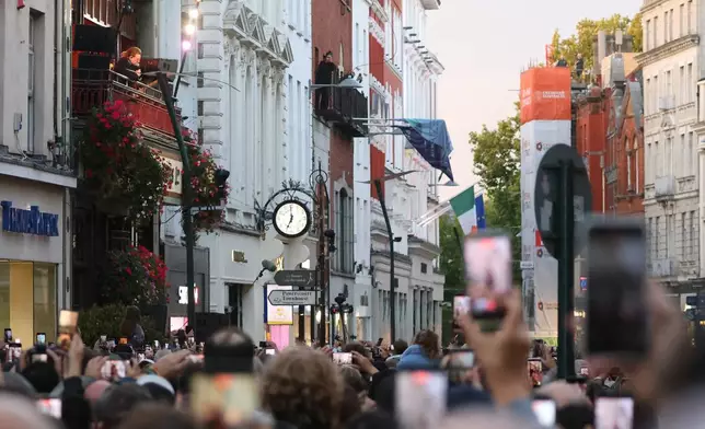 U2 perform an impromptu concert from a balcony in central Dublin, Ireland , Friday, Sept. 25, 2026. (AP Photo/Peter Morrison)