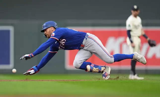 Texas Rangers' Brandon Nimmo dives to reach second base safely for an RBI-double during the second inning of a baseball game against the Minnesota Twins Saturday, Sept. 26, 2026, in Minneapolis. (AP Photo/Abbie Parr)