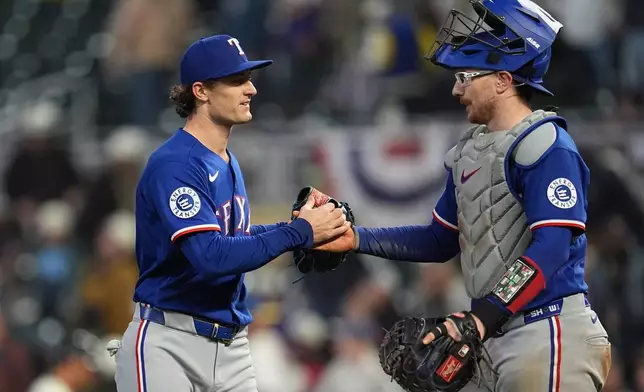 Texas Rangers relief pitcher Jacob Latz, left, and catcher Danny Jansen, right, shake hands after a baseball game against the Minnesota Twins, Saturday, Sept. 26, 2026, in Minneapolis. (AP Photo/Abbie Parr)