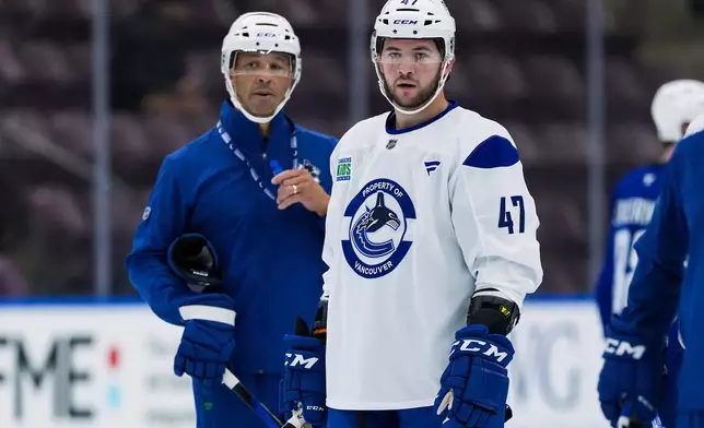 Vancouver Canucks' Paul Cotter (47) and head coach Manny Malhotra, left, look on during opening day of the NHL hockey team's training camp in Penticton, British Columbia, Thursday, Sept. 17, 2026. (Darryl Dyck/The Canadian Press via AP)