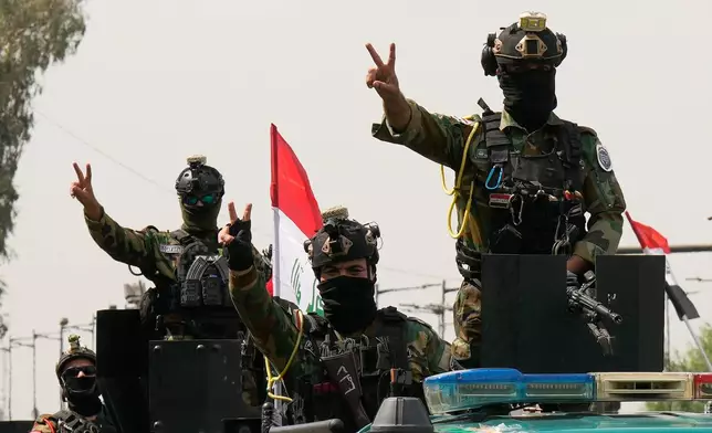 Iraqi security officers flash victory signs while riding in vehicles decorated with national flags during a convoy celebrating the complete withdrawal of U.S. troops from Iraq, in Baghdad, Iraq, Wednesday, Sept. 30, 2026. (AP Photo/Hadi Mizban)