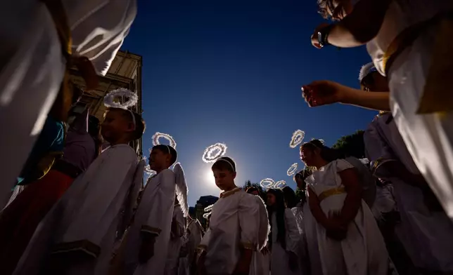 Children dressed as angels walk during an event dubbed the Little Angels' Parade, a Christian-themed street performance featuring dozens of children wearing angel costumes, in Bucharest, Romania, Saturday, Sept. 5, 2026. (AP Photo/ Andreea Alexandru)