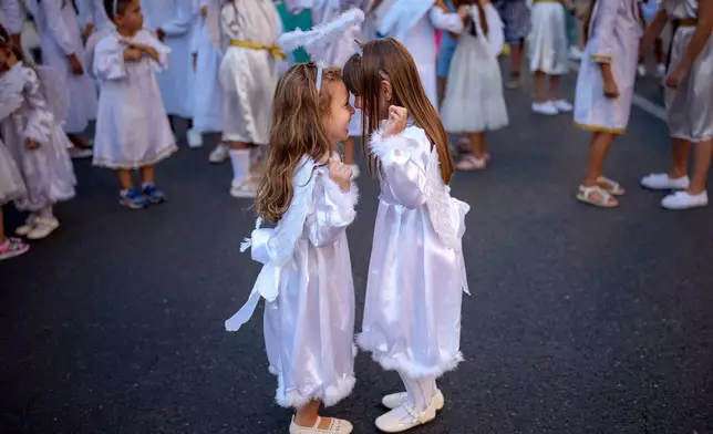 Children dressed as angels dance during an event dubbed the Little Angels' Parade, a Christian-themed street performance featuring dozens of children wearing angel costumes, in Bucharest, Romania, Saturday, Sept. 5, 2026. Sept. 5, 2026. (AP Photo/ Andreea Alexandru)