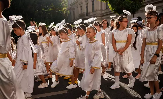 Children dressed as angels walk during an event dubbed the Little Angels' Parade, a Christian-themed street performance featuring dozens of children wearing angel costumes, in Bucharest, Romania, Saturday, Sept. 5, 2026. (AP Photo/ Vadim Ghirda)