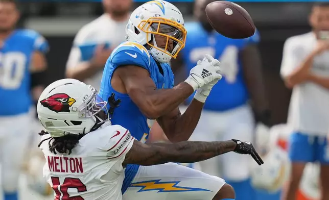 Arizona Cardinals cornerback Max Melton, left, breaks up a pass intended for Los Angeles Chargers running back Omarion Hampton during the first half of an NFL football game Sunday, Sept. 13, 2026, in Inglewood, Calif. (AP Photo/Gregory Bull)