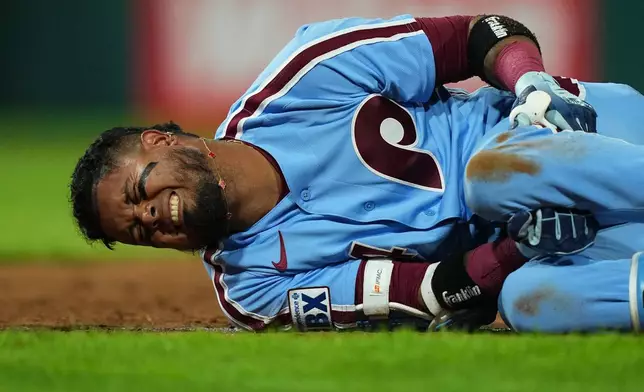 Philadelphia Phillies' Luis Arraez rects to an injury after being thrown out at first base during the sixth inning of a baseball game against the Milwaukee Brewers, Thursday, Sept. 24, 2026, in Philadelphia. (AP Photo/Matt Rourke)