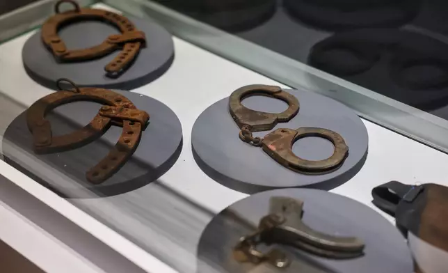 Handcuffs and other restraints are displayed at "When the Walls Speak," an exhibit at the Damascus International Fair featuring items from Syrian prisons and security branches during the rule of former President Bashar Assad, in Damascus, Syria, Monday, Aug. 31, 2026. (AP Photo/Ghaith Alsayed)