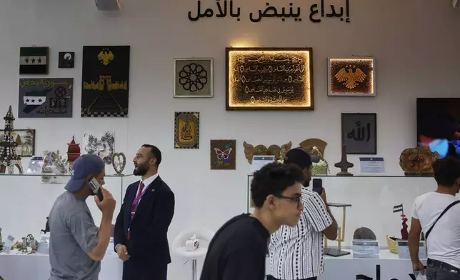 Visitors browse a display of artwork and handicrafts said to have been made by inmates currently held in Syrian prisons at the 63rd Damascus International Fair on the outskirts of Damascus, Syria, Monday, Aug. 31, 2026. (AP Photo/Ghaith Alsayed)