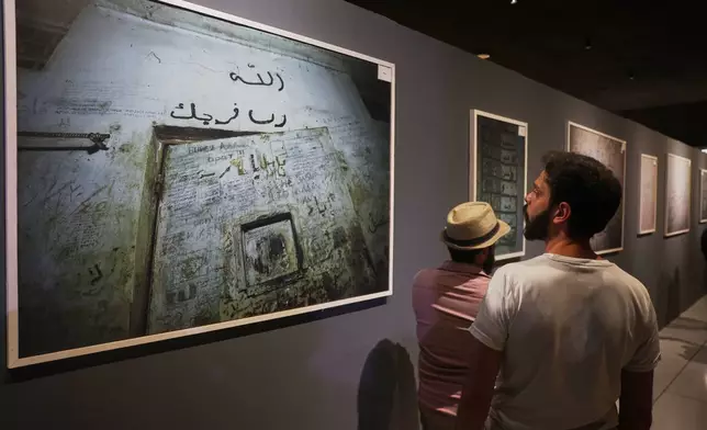 Visitors view photographs of Syria's Saydnaya prison displayed at "When the Walls Speak," an exhibit at the Damascus International Fair featuring items and images from prisons during the rule of former President Bashar Assad, in Damascus, Syria, Monday, Aug. 31, 2026. (AP Photo/Ghaith Alsayed)