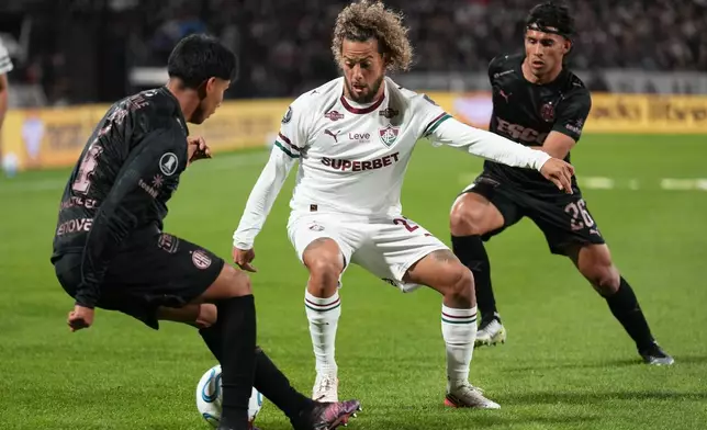 Guga of Brazil's Fluminense, center, and Alvaro Lagos of Argentina's Platense battle for the ball during a Copa Libertadores quarter final second leg soccer match in Buenos Aires, Argentina, Tuesday, Sept. 15, 2026. (AP Photo/Gustavo Garello)