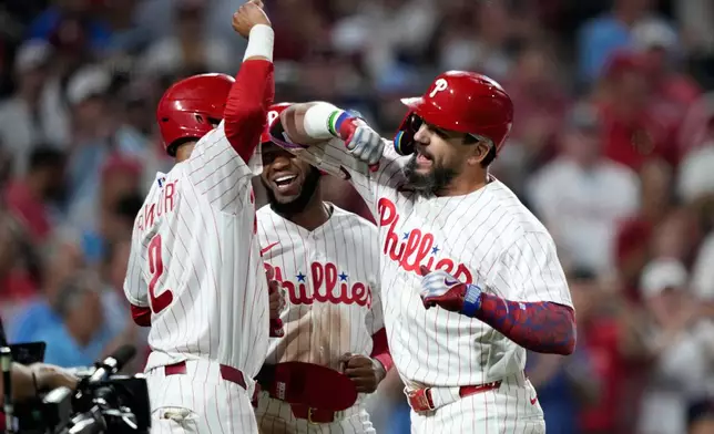 Philadelphia Phillies' Kyle Schwarber, from right, Bryan de la Cruz and Justin Crawford celebrate after Schwarber's grand slam during the sixth inning of a baseball game against the Houston Astros Wednesday, Sept. 9, 2026, in Philadelphia. (AP Photo/Matt Slocum)