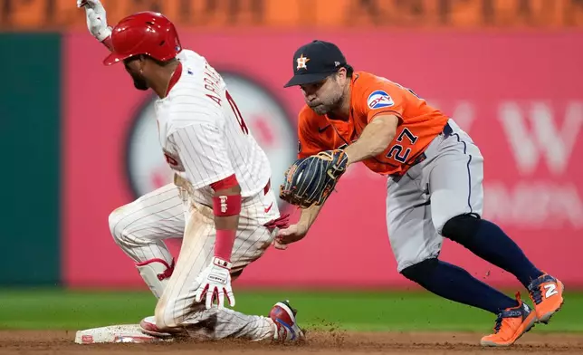 Philadelphia Phillies' Luis Arraez, left, slides into second for a double past Houston Astros second baseman Jose Altuve during the sixth inning of a baseball game Wednesday, Sept. 9, 2026, in Philadelphia. (AP Photo/Matt Slocum)