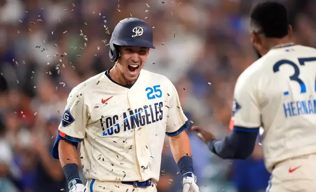 Los Angeles Dodgers' Tommy Edman, left, has seeds thrown at him by Teoscar Hernández after hitting a three-run home run during the seventh inning of a baseball game against the Washington Nationals, Saturday, Sept. 5, 2026, in Los Angeles. (AP Photo/Mark J. Terrill)