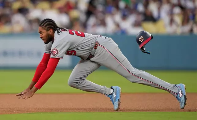 Washington Nationals' James Wood dives as he steals second during the third inning of a baseball game against the Los Angeles Dodgers, Saturday, Sept. 5, 2026, in Los Angeles. (AP Photo/Mark J. Terrill)