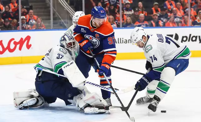 Edmonton Oilers' Connor McDavid (97) looks for the rebound from Vancouver Canucks' goaltender Kevin Lankinen (32) during overtime NHL hockey action in Edmonton on Tuesday, Sept. 29, 2026. (Codie McLachlan/The Canadian Press via AP)